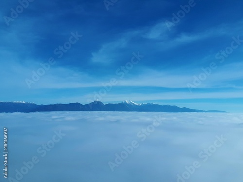 View of Gorenjska region of Slovenia covered in low level stratus clouds with snow covered peaks of Kamnik-Savinja alps in the background