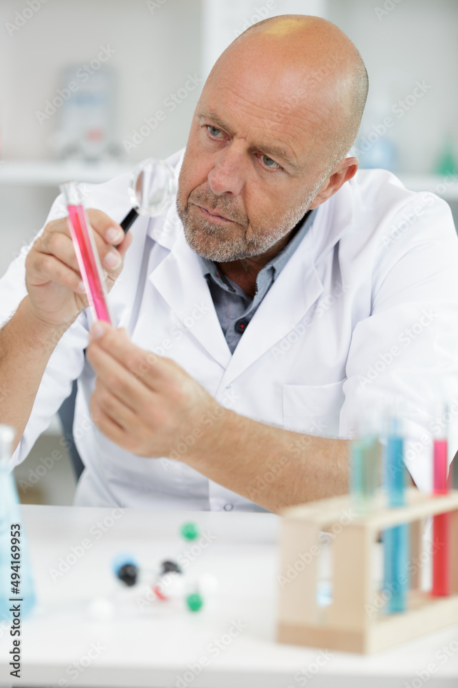 portrait man of mature scientist holding magnifying glass in lab portrait man of mature scientist holding magnifying glass in lab