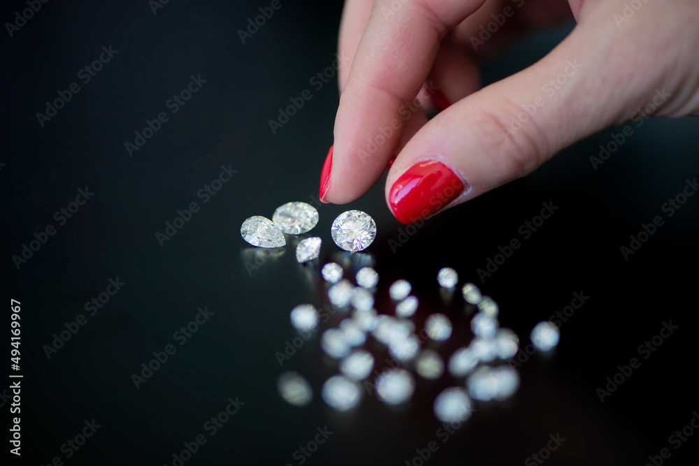 Diamonds are placed on a black table , Diamonds , A woman holding diamonds, a woman's hand touching a diamond , Diamonds on a black background Diamonds are placed on a black table , Diamonds , A woman holding diamonds, a woman's hand touching a diamond , Diamonds on a black background