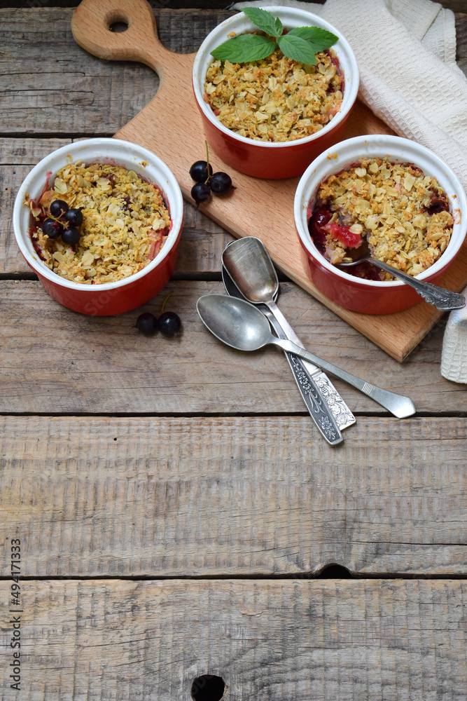 Fruits casserole or crumble with apples and berries in brown cup ramekin. Copy space. Photographing with natural light. Fruits casserole or crumble with apples and berries in brown cup ramekin. Copy space. Photographing with natural light.