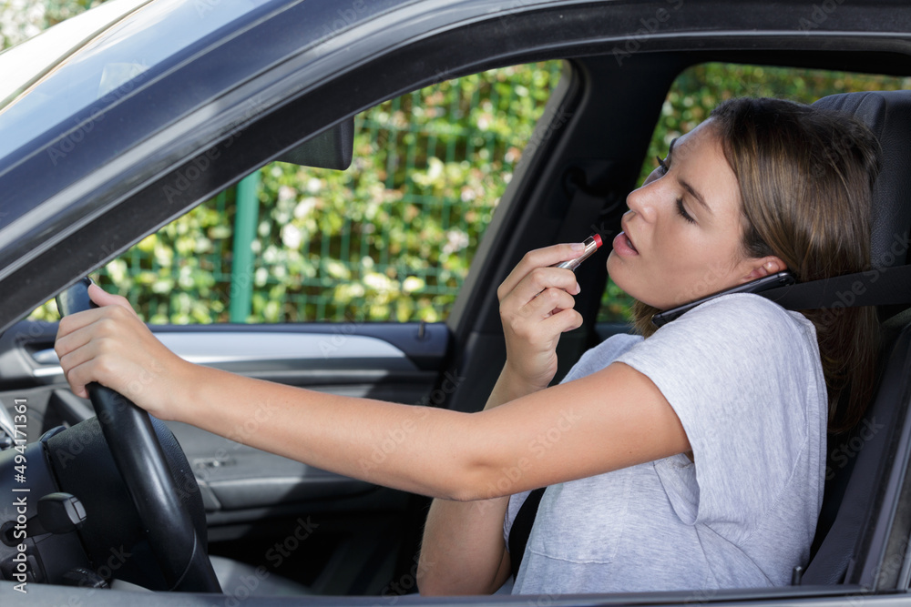 woman in car making up her lips woman in car making up her lips