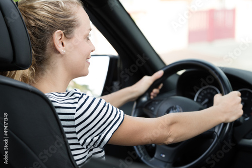 young woman driver driving a business car