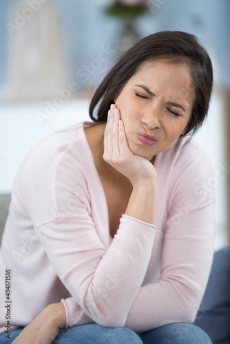 young woman with sensitive teeth at home