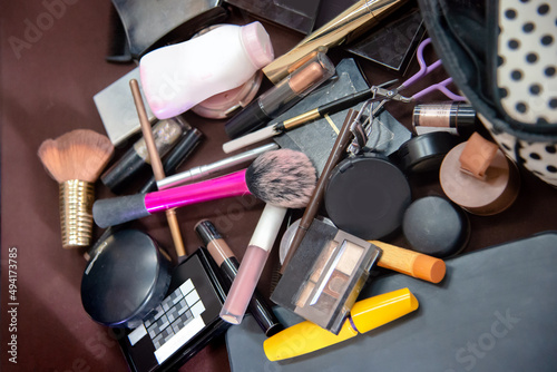 Pile of messy cosmatics makeup on table photo