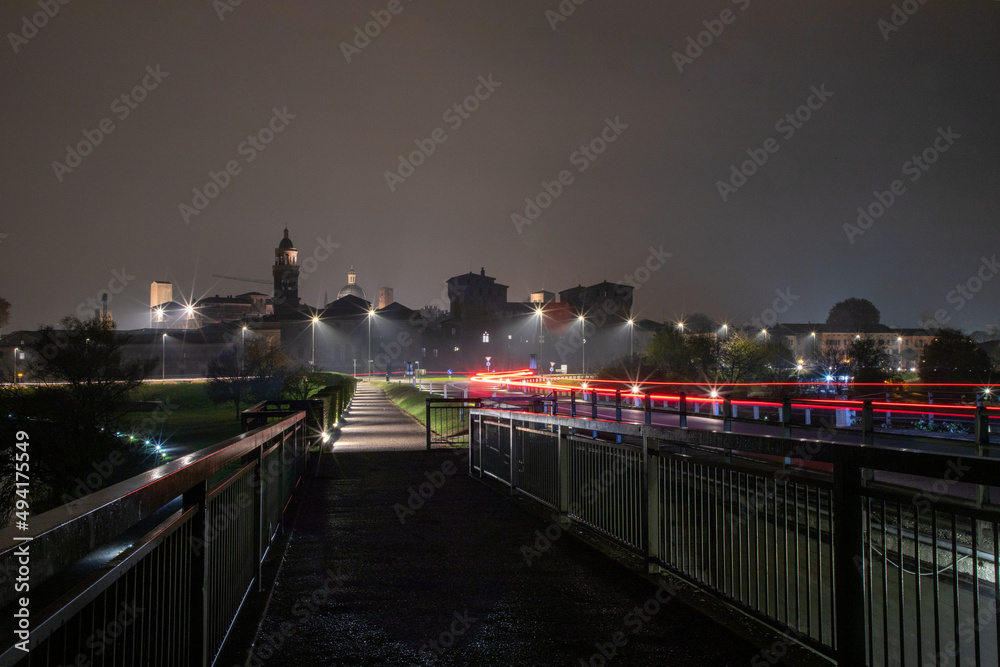 View of the city of Mantova at night with a car making the wake. Photo taken on the San Giorgio bridge.