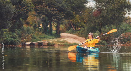 Banner of kayaking. Happy young caucasian woman floating in blue kayak at river. Copy space. The concept of World Tourism Day