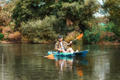 Happy adult caucasian man kayaking at the river. Copy space. The concept of the World Tourism Day