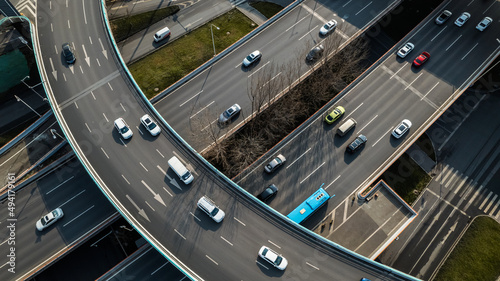 Top up aerial drone view of elevated road and traffic junctions in Chinese metropolis city Chengdu during sunny day. Modern construction design of traffic ways to avoid traffic jams. Few vehicles.