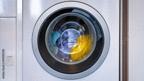 Colorful laundry inside a front loader washing machine photo