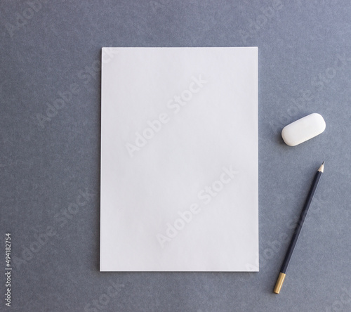 White paper and pencil on a gray background. Design. Mock up. Copy space.