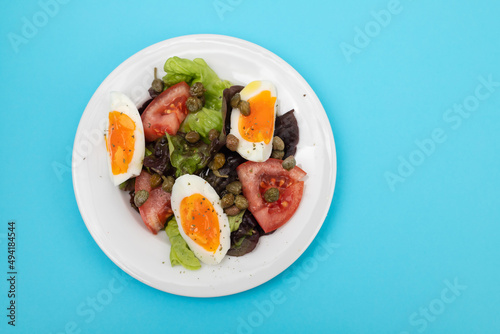 fresh vegetable salad with boiled egg on white dish