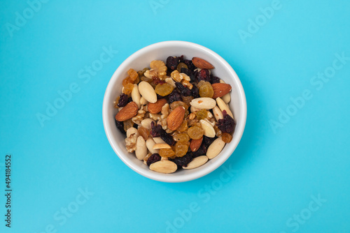 dry fruits in white small bowl on blue paper