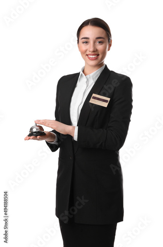 Happy young receptionist in uniform holding service bell on white background