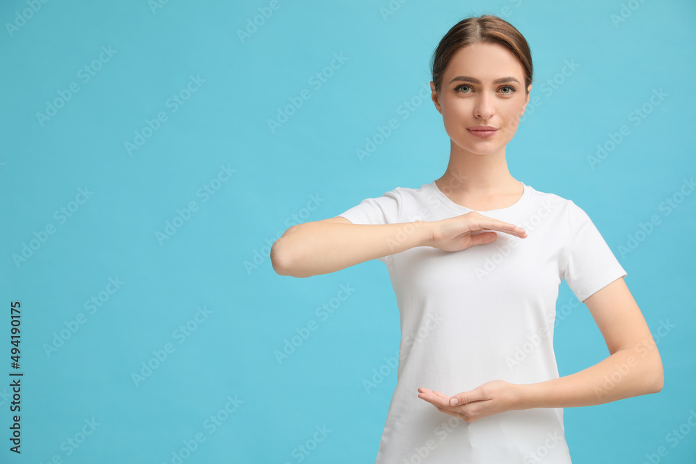 Young woman holding hands near chest on turquoise background, closeup. Space for text Young woman holding hands near chest on turquoise background, closeup. Space for text