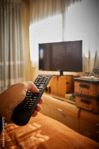 Acción de encender la televisión con mando a distancia en primera persona