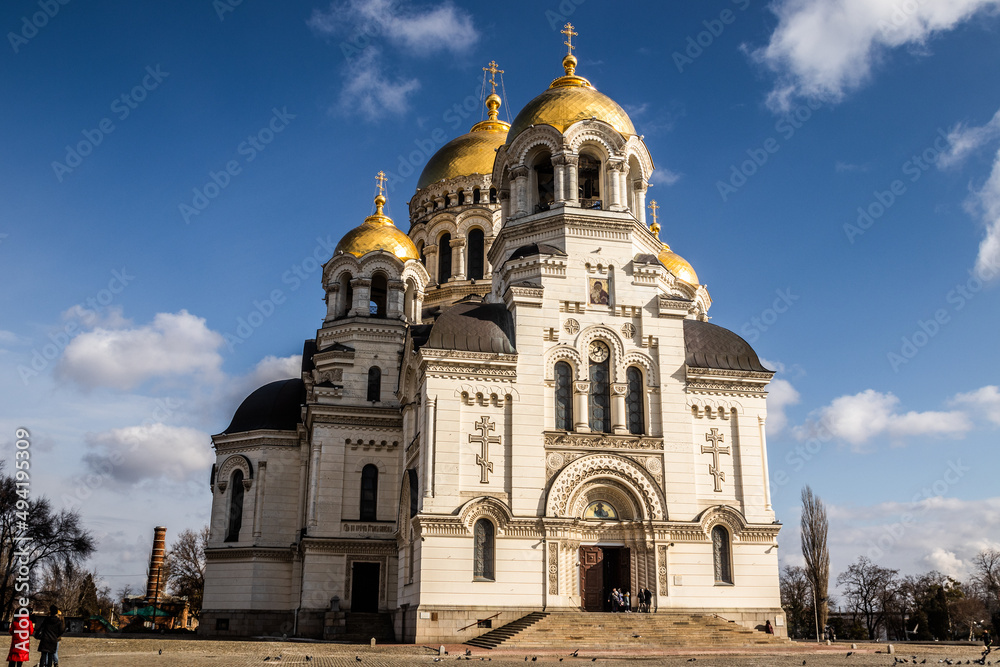 Orthodox church with golden domes and crosses against a clear blue sky with clouds. view of the Ascension Cathedral in the town of Novocherkassk.Russia.
