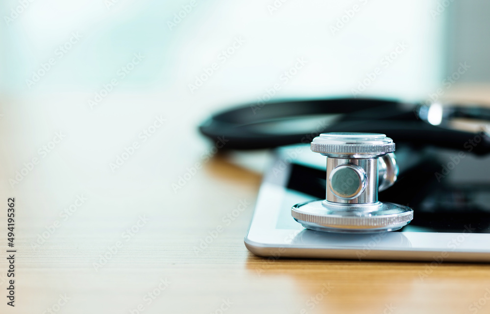 Fototapeta premium Stethoscope with medical tablet on wooden table