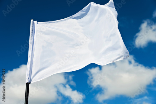 White flag flying against blue sky photo