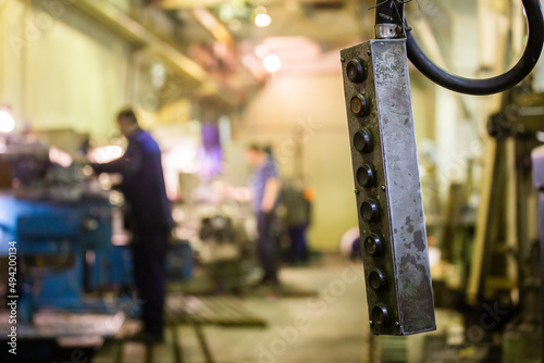 shop crane control panel box with blurry milling workers in the background photo