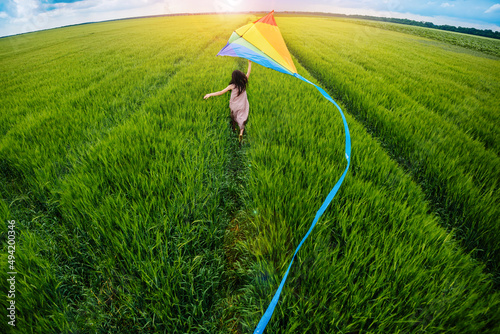 Canvastavla Little happy girl running with kate in hands on green wheat field