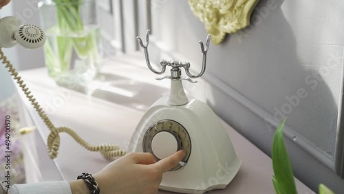 Close-up of woman's hand dialing number on an old retro phone with round disk HD video