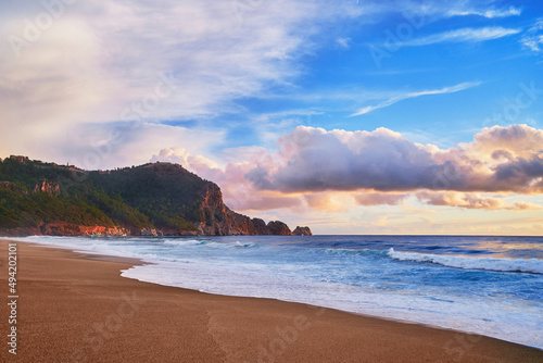 Landscape of scenic idyllic peaceful calm sky wallpaper with fluffy clouds, green mountain ridge, sea coast and sandy beach