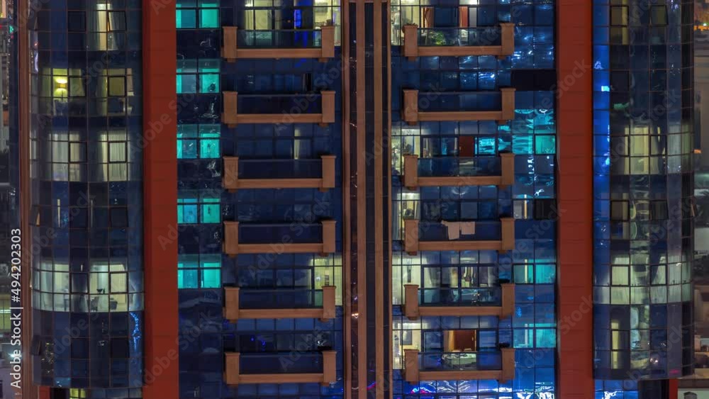 Night aerial view of apartment building glass window facade with illuminated lighted workspace rooms timelapse. Night aerial view of apartment building glass window facade with illuminated lighted workspace rooms timelapse.