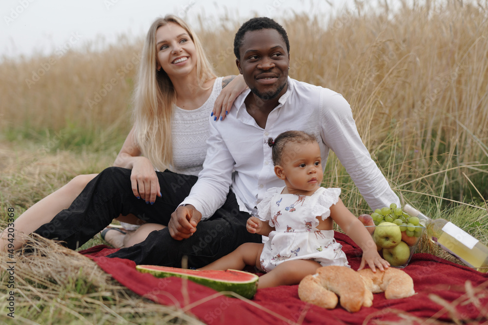 Portrait of loving parents and their daughter having picnic