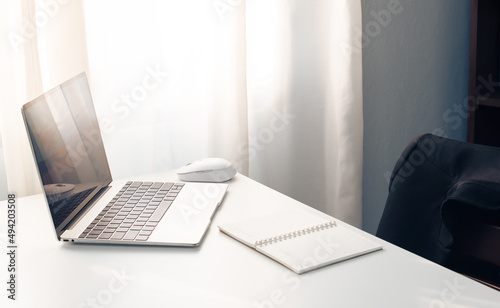 Desktop computer screen on white desk, interior of working room, work from home. home interior of open work space with white desk. packing parcel box for online shipping delivery. small home business.