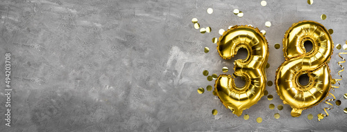 Yellow foil balloon number, number thirty eight on a concrete background. Greeting card with the inscription 38. Anniversary concept. for anniversary, birthday, new year celebration. banner © mtrlin