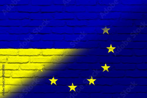 European Union (EU) and Ukraine. European Union flag and Ukraine flag. Concept of aid, association of countries, political and economic relations. Flag with brick wall texture. OTAN-NATO flag.