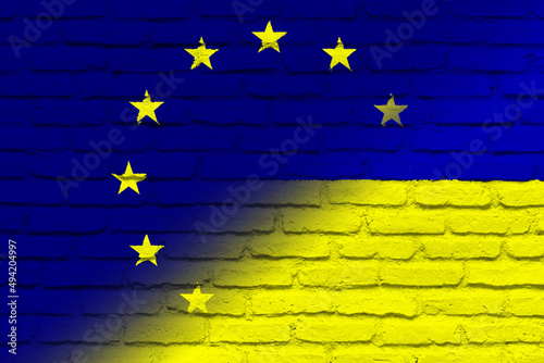 European Union (EU) and Ukraine. European Union flag and Ukraine flag. Concept of aid, association of countries, political and economic relations. Flag with brick wall texture. OTAN-NATO flag.