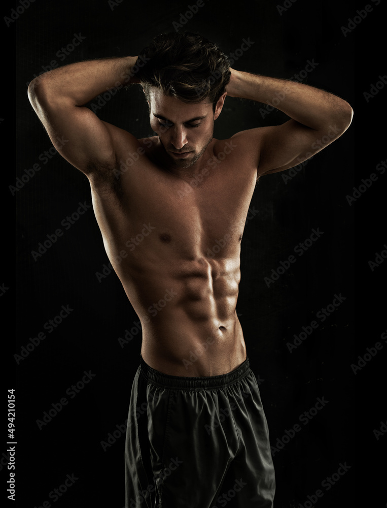Chiseled abs. Muscular young man showing off his defined body.