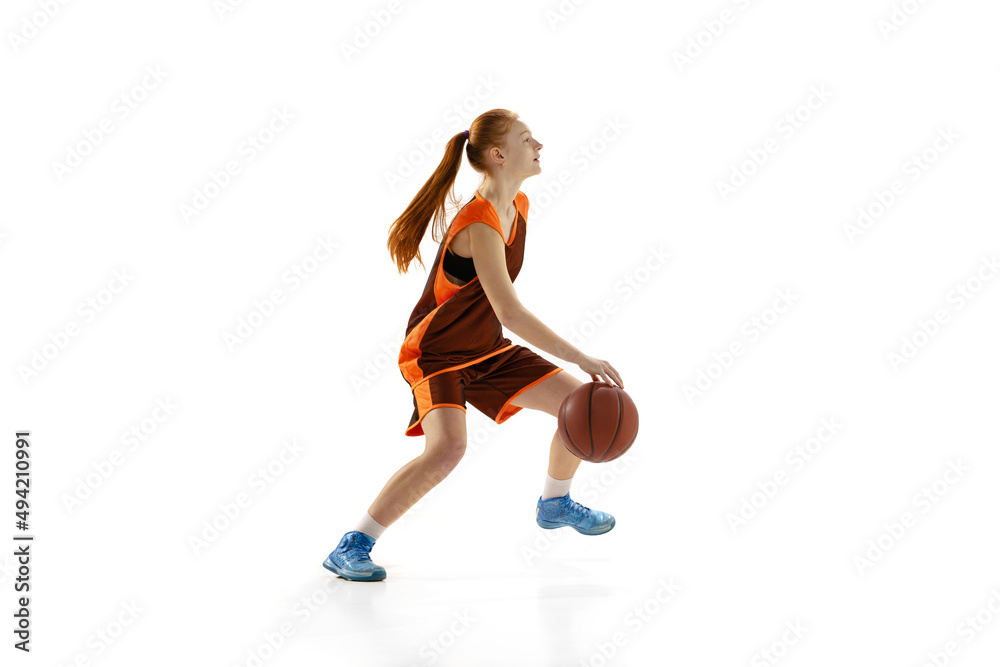 Portrait of young girl, teen, basketball player in motion, training isolated oer white studio background. Outlet pass.