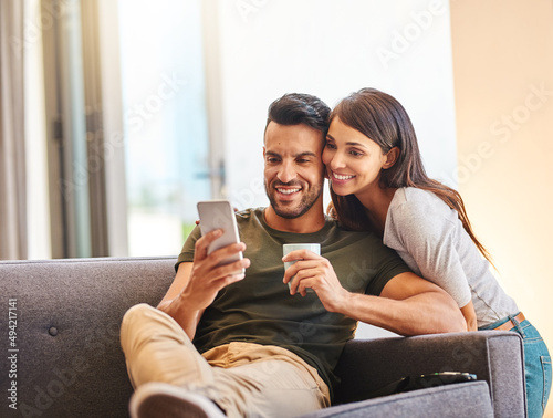 Come in for a selfie, babe. Shot of a young couple taking selfies together at home.