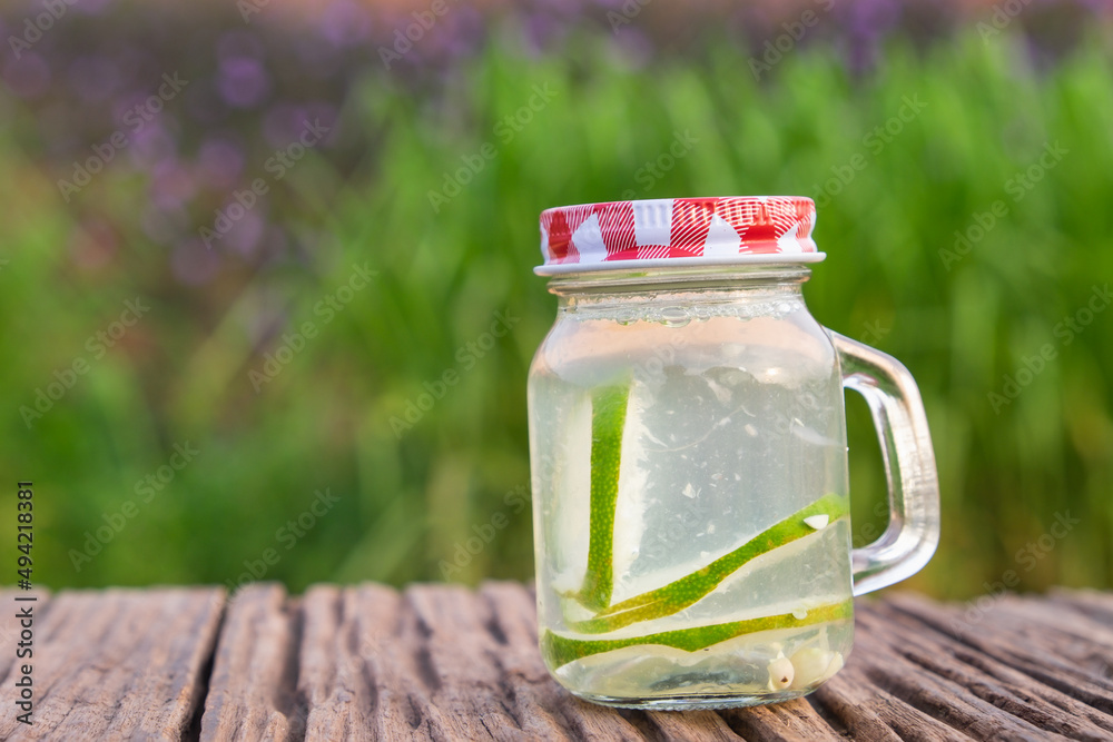 Detox water with lime in jar against rustic wood. Detox water with lime in jar against rustic wood.