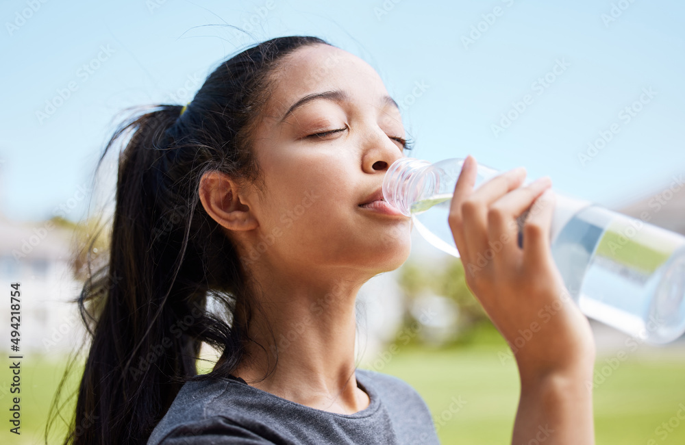 Water never tastes better than after you break a sweat. Shot of a young woman drinking water after her workout at the park. Water never tastes better than after you break a sweat. Shot of a young woman drinking water after her workout at the park.