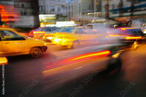 blurred background with light of taxi and cars driving on road at night with speed motion © berna_namoglu