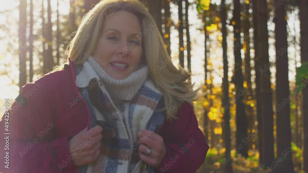 Mature woman wrapping herself In warm coat on walk through fall or winter countryside - shot in slow motion Mature woman wrapping herself In warm coat on walk through fall or winter countryside - shot in slow motion