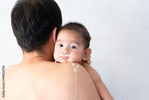 Close up of asian father is carring his baby to belching after breast feeding time, conceptnof parent care to the child and over feeding in baby.
