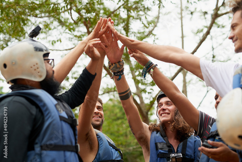 Getting hyped up for the rafting. Cropped shot of a group of young male friends giving each other a high five before they go white water rafting. © Adene S/peopleimages.com