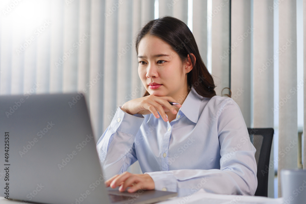 Business concept, Businesswoman thoughtful about new project while reading marketing data on laptop Business concept, Businesswoman thoughtful about new project while reading marketing data on laptop