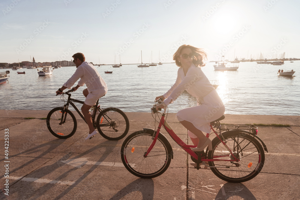 Fototapeta premium Senior couple enjoying a beautiful morning together riding a bike by the sea. Selective focus