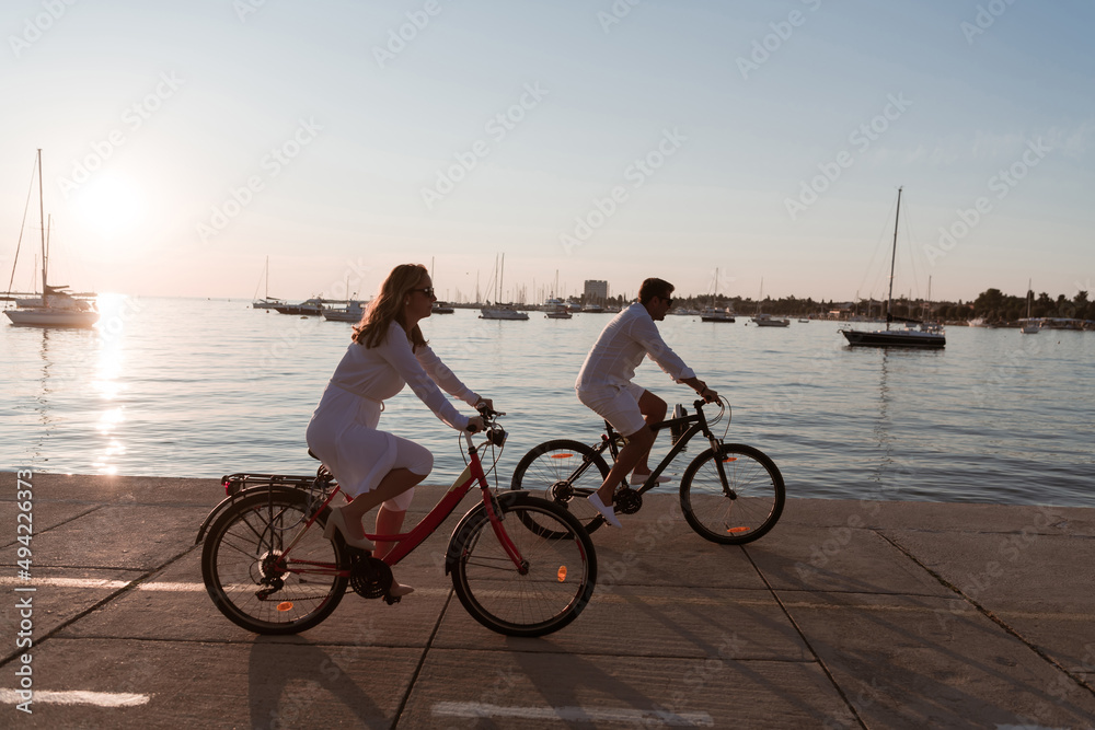 Obraz premium Senior couple enjoying a beautiful morning together riding a bike by the sea. Selective focus