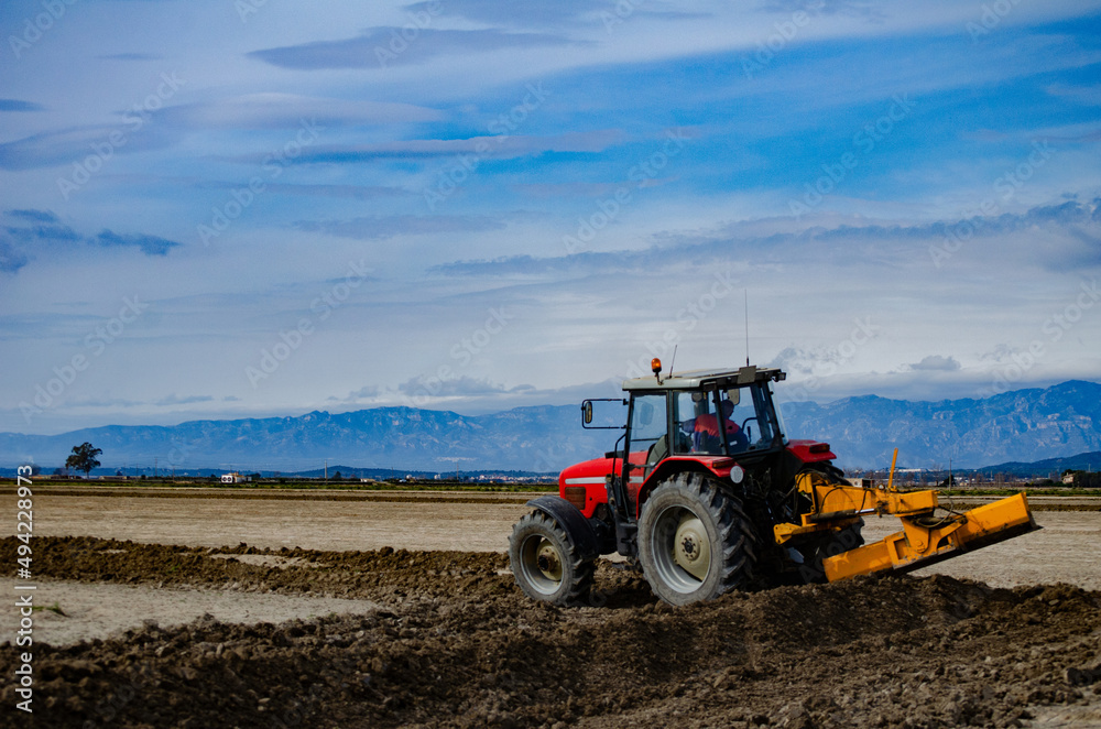 Tractor worked the crop field on a sunny summer day Tractor worked the crop field on a sunny summer day