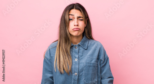 pretty hispanic woman looking goofy and funny with a silly cross-eyed expression, joking and fooling around photo