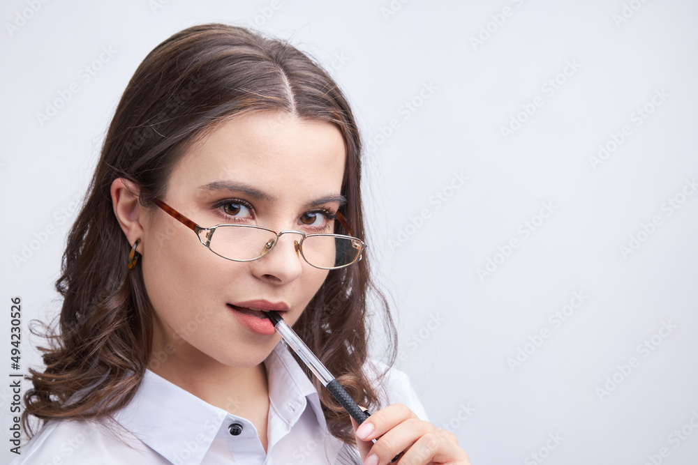 sexy young woman sexy looking with glasses, with a pen at her mouth sexy young woman sexy looking with glasses, with a pen at her mouth