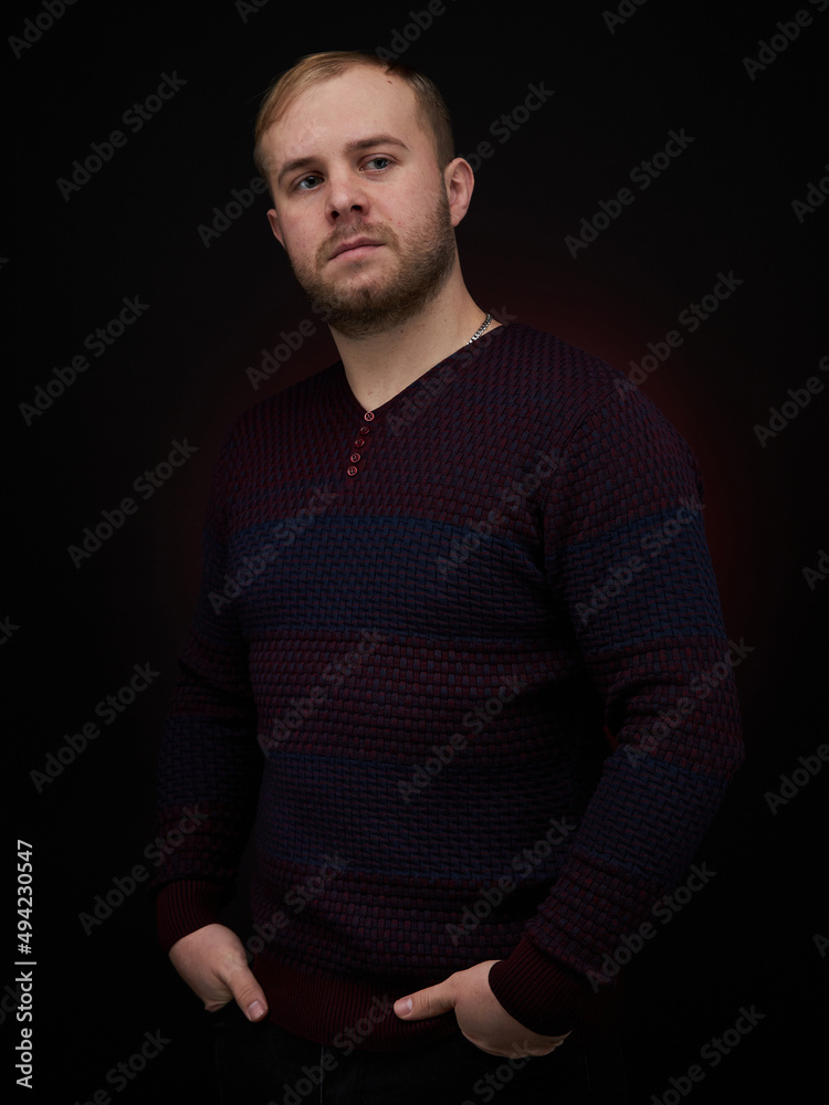 vertical portrait blond man on a dark background, in a jacket vertical portrait blond man on a dark background, in a jacket