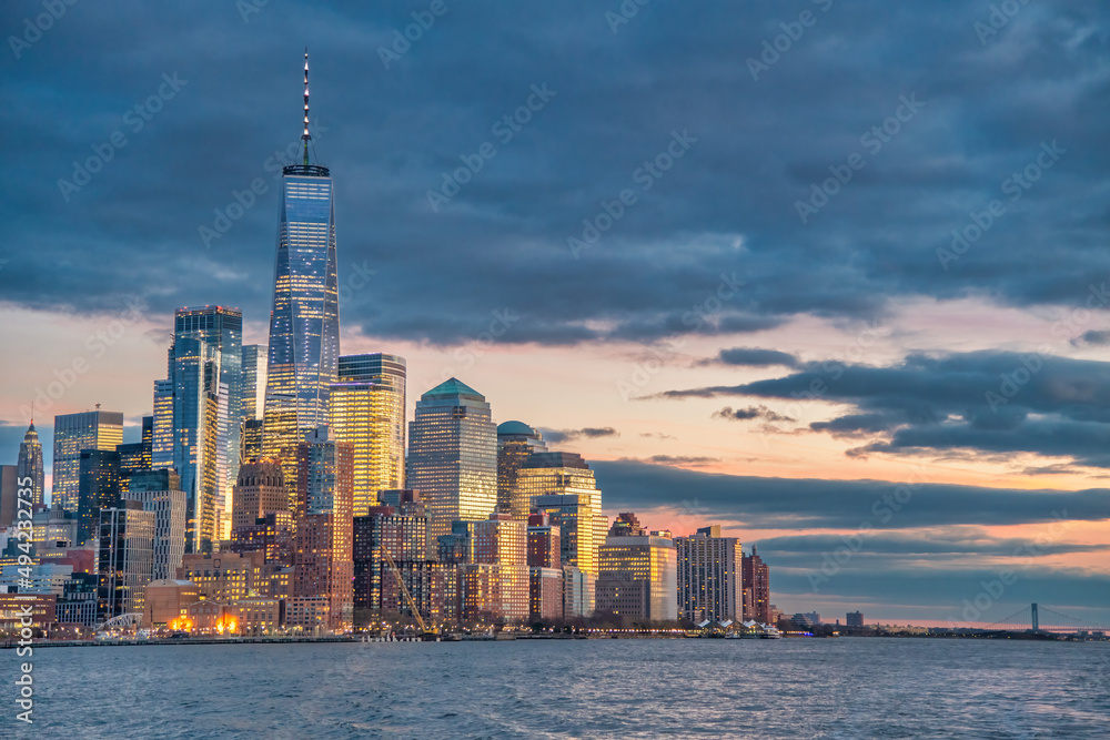 Sunset skyline of Downtown Manhattan as seen from a ferry boat tour around New York City.