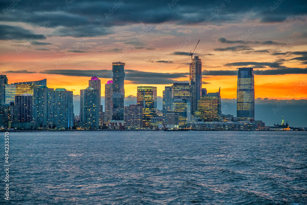 Fototapeta premium Sunset skyline of Jersey City as seen from a ferry boat tour aound New York City.